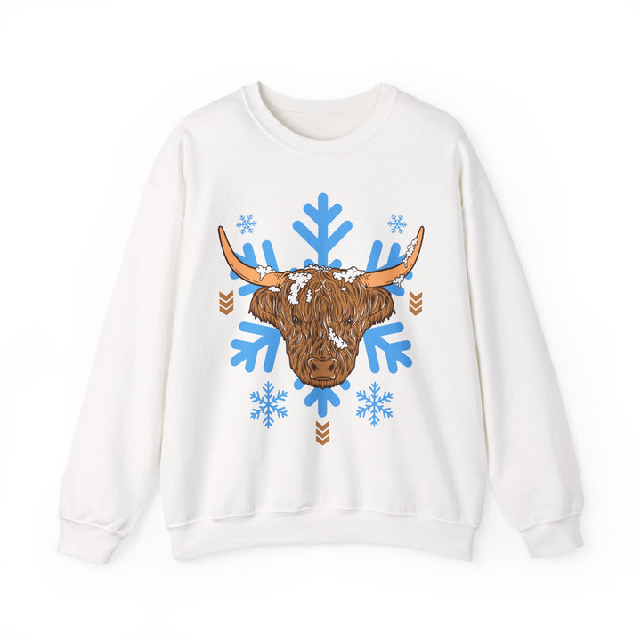 Shaggy brown Highland cow head centered over large light-blue snowflakes