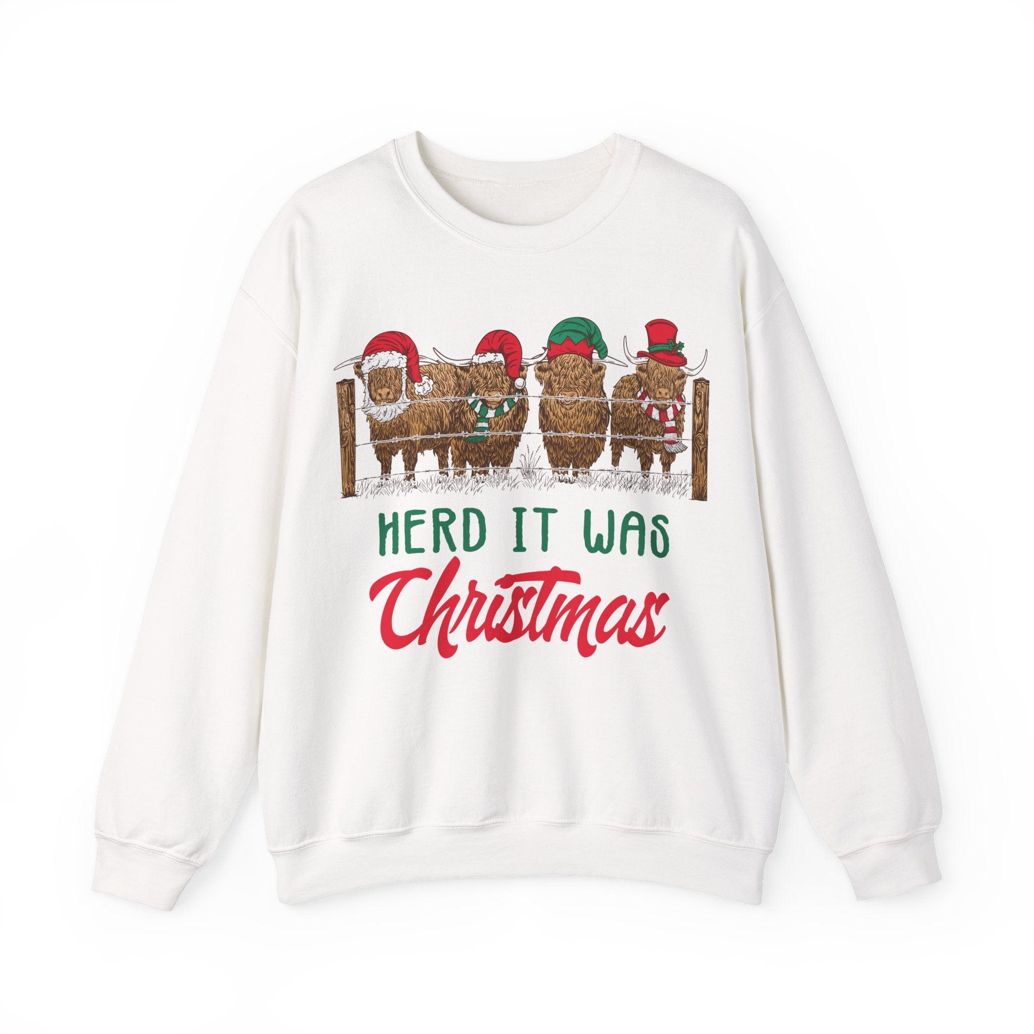 Four Highland cows lined up behind a wooden fence wearing Santa and elf hats with Herd It Was Christmas lettering in green and red