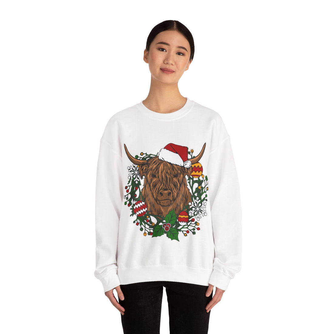 Shaggy Highland cow wearing a Santa hat framed by a holly and ornament Christmas wreath, alternate view