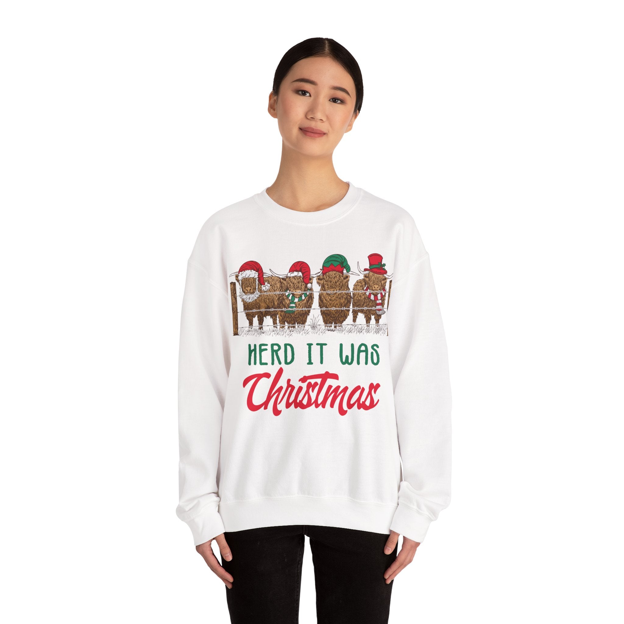 Four Highland cows lined up behind a wooden fence wearing Santa and elf hats with Herd It Was Christmas lettering in green and red, color option