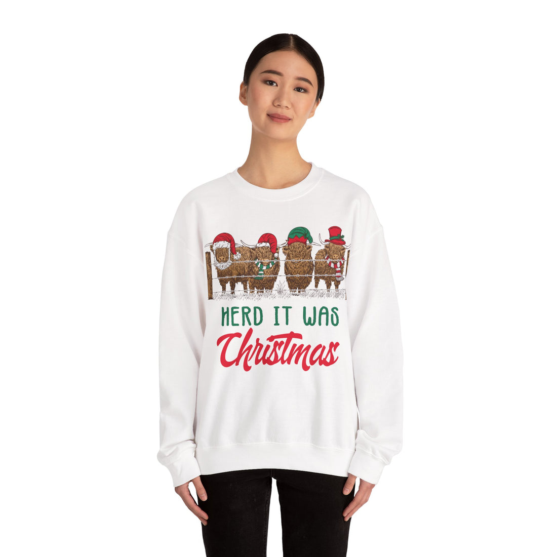 Four Highland cows lined up behind a wooden fence wearing Santa and elf hats with Herd It Was Christmas lettering in green and red, color option